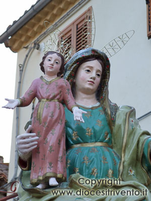 Primo piano della statua addobbata con le corone