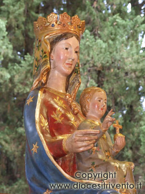 Un primo piano della statua della Madonna che sorride e di Gesù Bambino