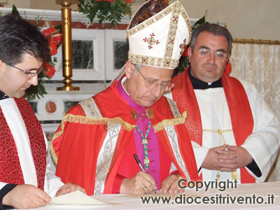 Il Vescovo mons. Scotti, assistito dal Parroco don Erminio Gallo e dal cerimoniere vescovile, firma il verbale come prescrive il diritto canonico