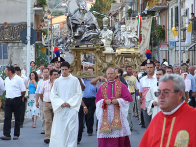 Il vescovo Mons.Scotti, in preghiera, precede le Statue dei Santi Patroni