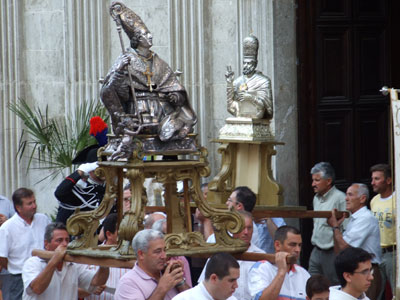 Le statue dei Patroni lasciano la cattedrale e, portate in spalla, si apprestano ad attraversare le vie del paese