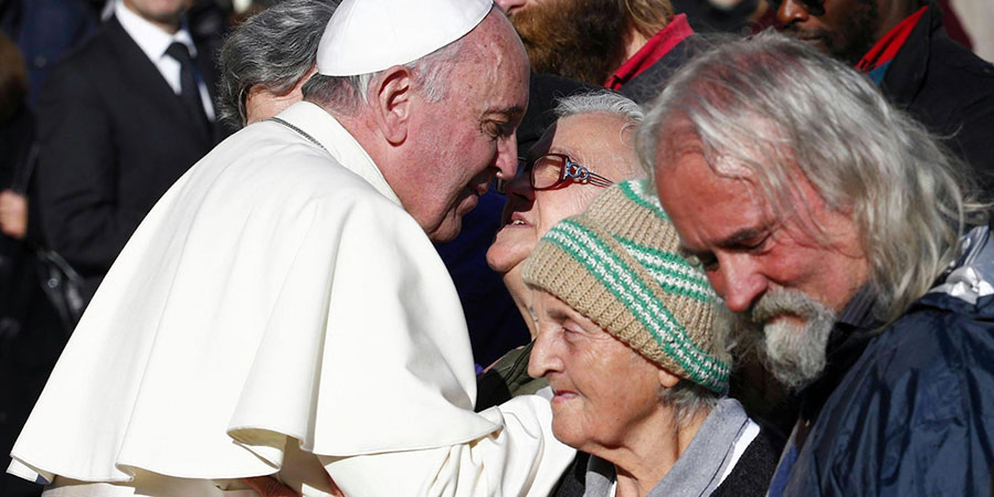 Un'immagine di Papa Francesco metre incontra delle persone povere