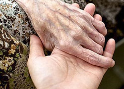 Una foto di due mani, quella di un anziano e di un bambino